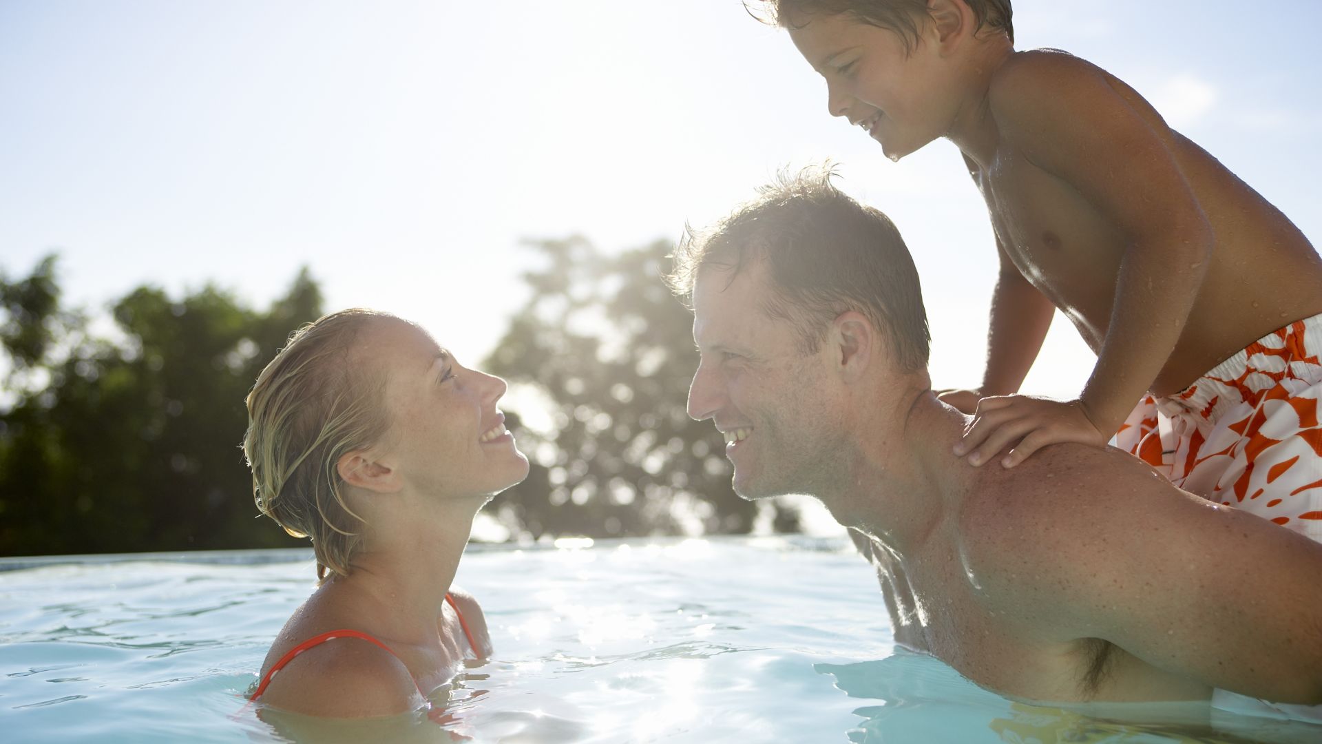 Family of three in swimming pool