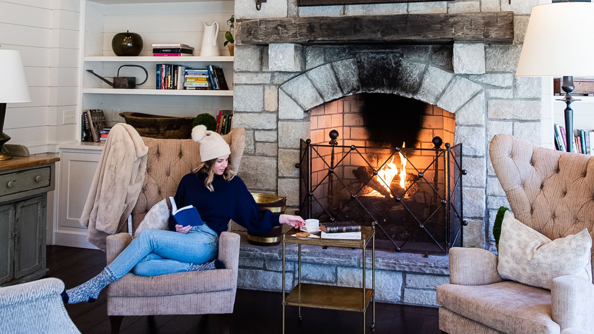 A Person Sitting In A Living Room With A Fireplace