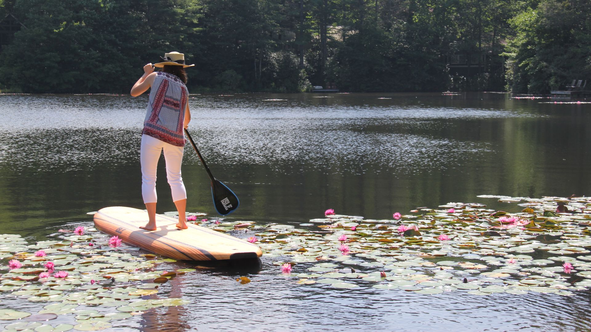 A Person Paddle Boarding On A Lake