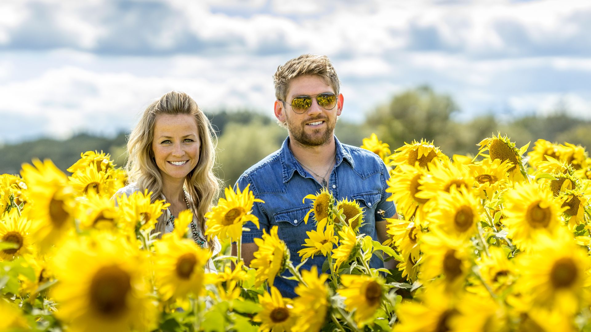 A Man And Woman In A Field Of Yellow Flowers